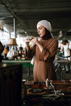 A woman inspects a vintage camera at an Antalya antiques market, showcasing cultural interest and fashion.