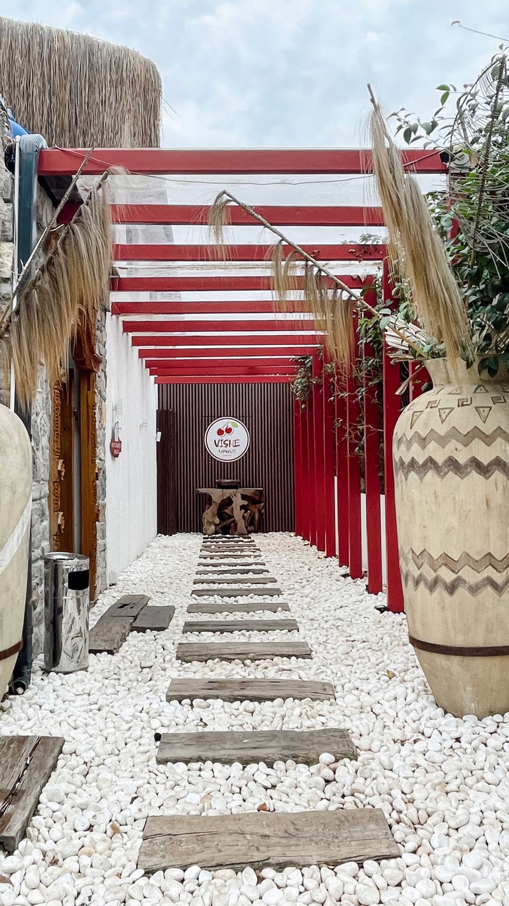 Stylish outdoor patio with a red pergola and stone path