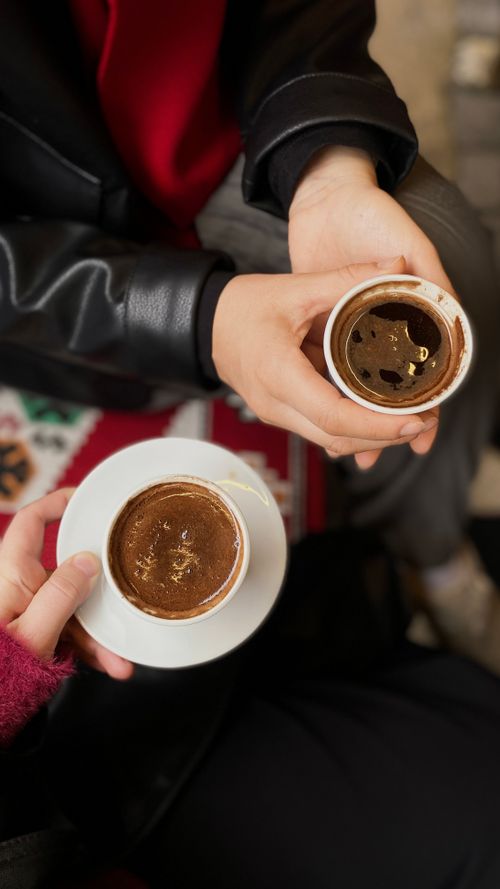 Free Two people sharing traditional Turkish coffee in small cups, emphasizing friendship and culture. Stock Photo