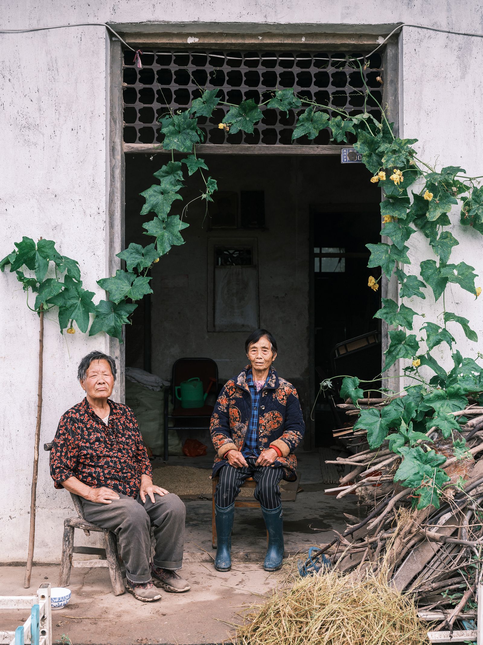 中国乡村，门前坐着的老人望向镜头