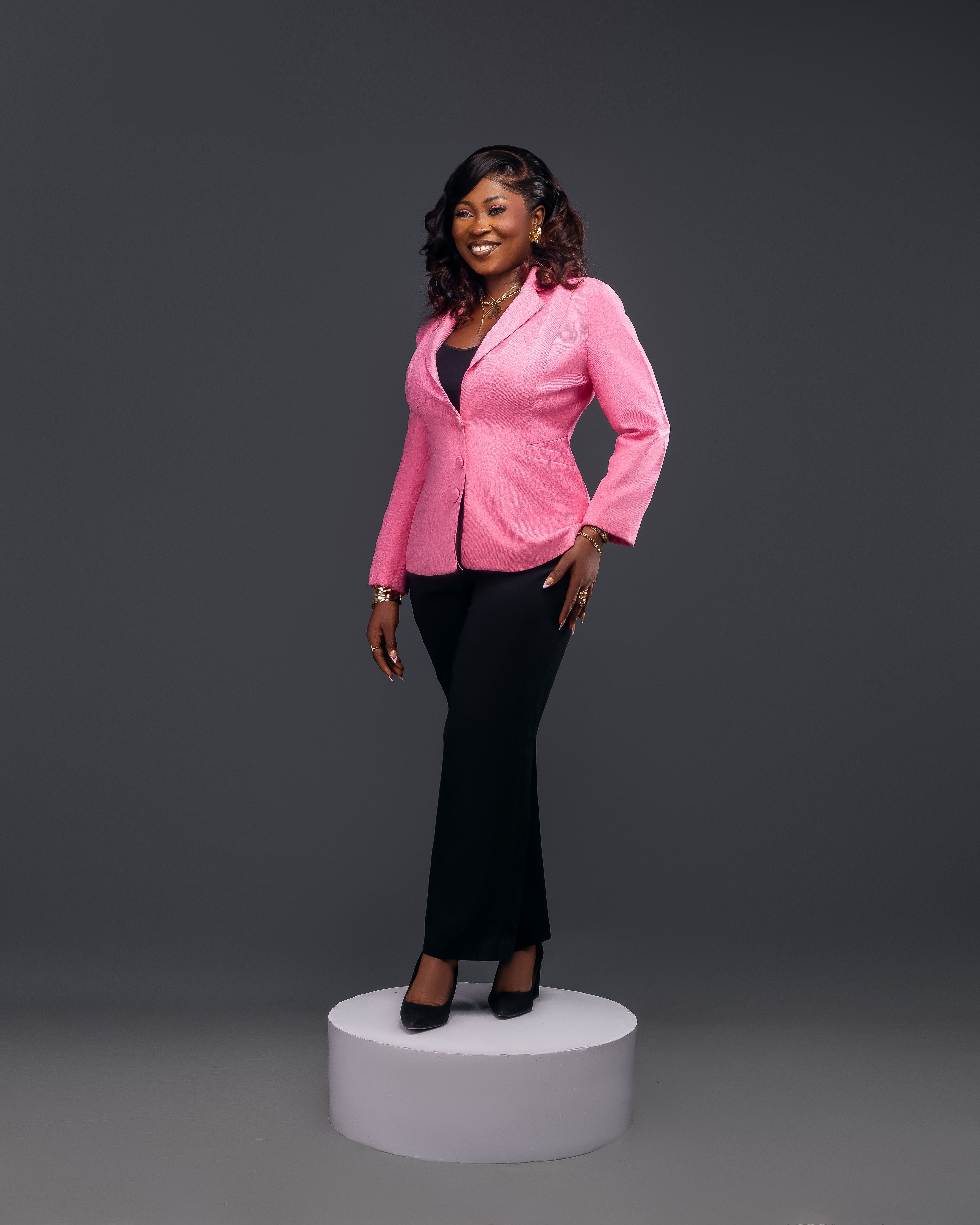 Elegant woman standing confidently in a pink blazer, perfect for corporate and business themes.