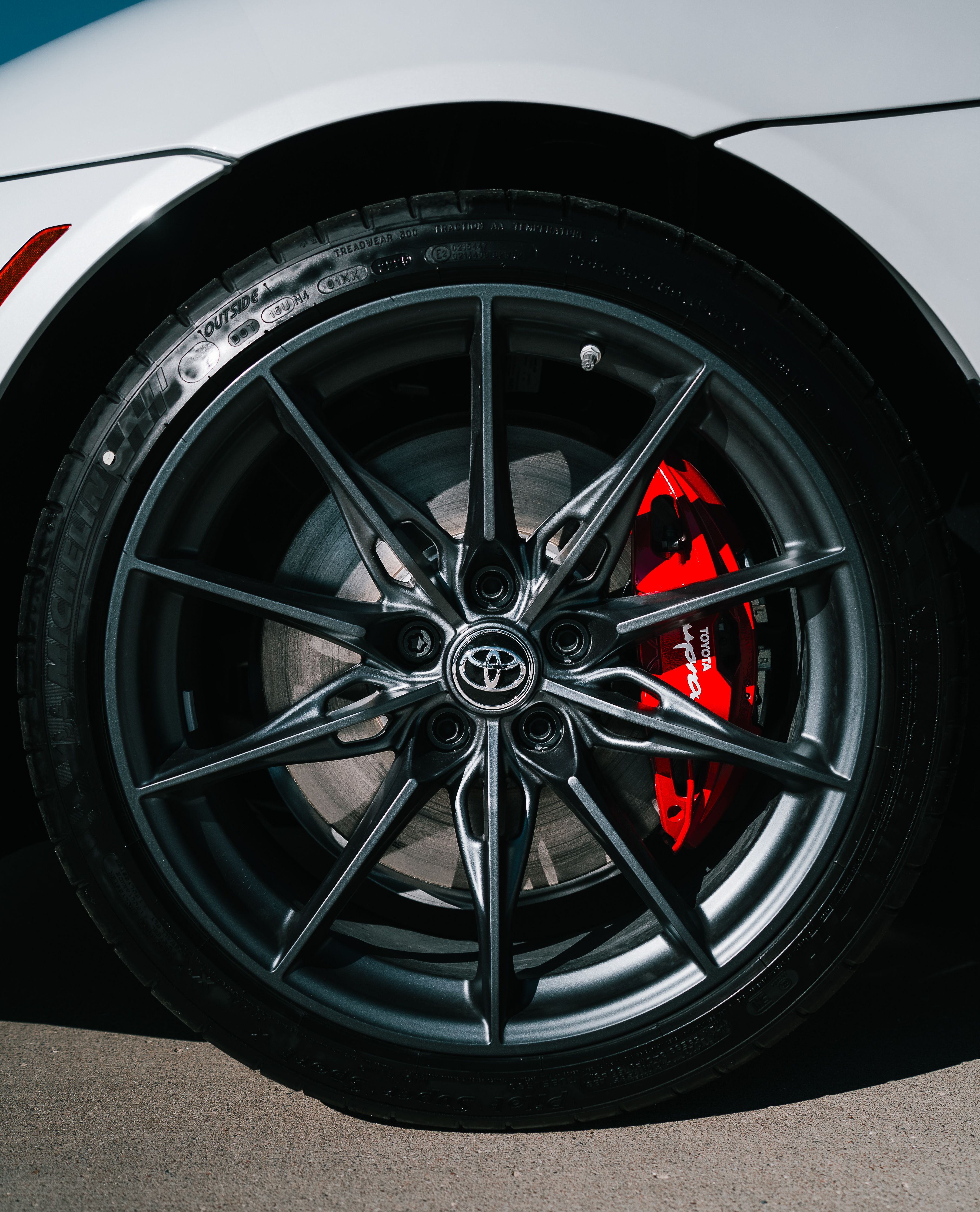 Close-up of Car Alloy Wheel with Red Brake Caliper · Free Stock Photo
