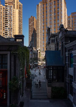 Vibrant cityscape featuring towering skyscrapers, historic architecture, and people strolling on a sunny day.