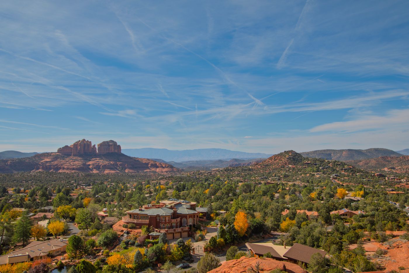 Wide aerial view of Sedona’s red rocks, greenery, and surrounding landscape