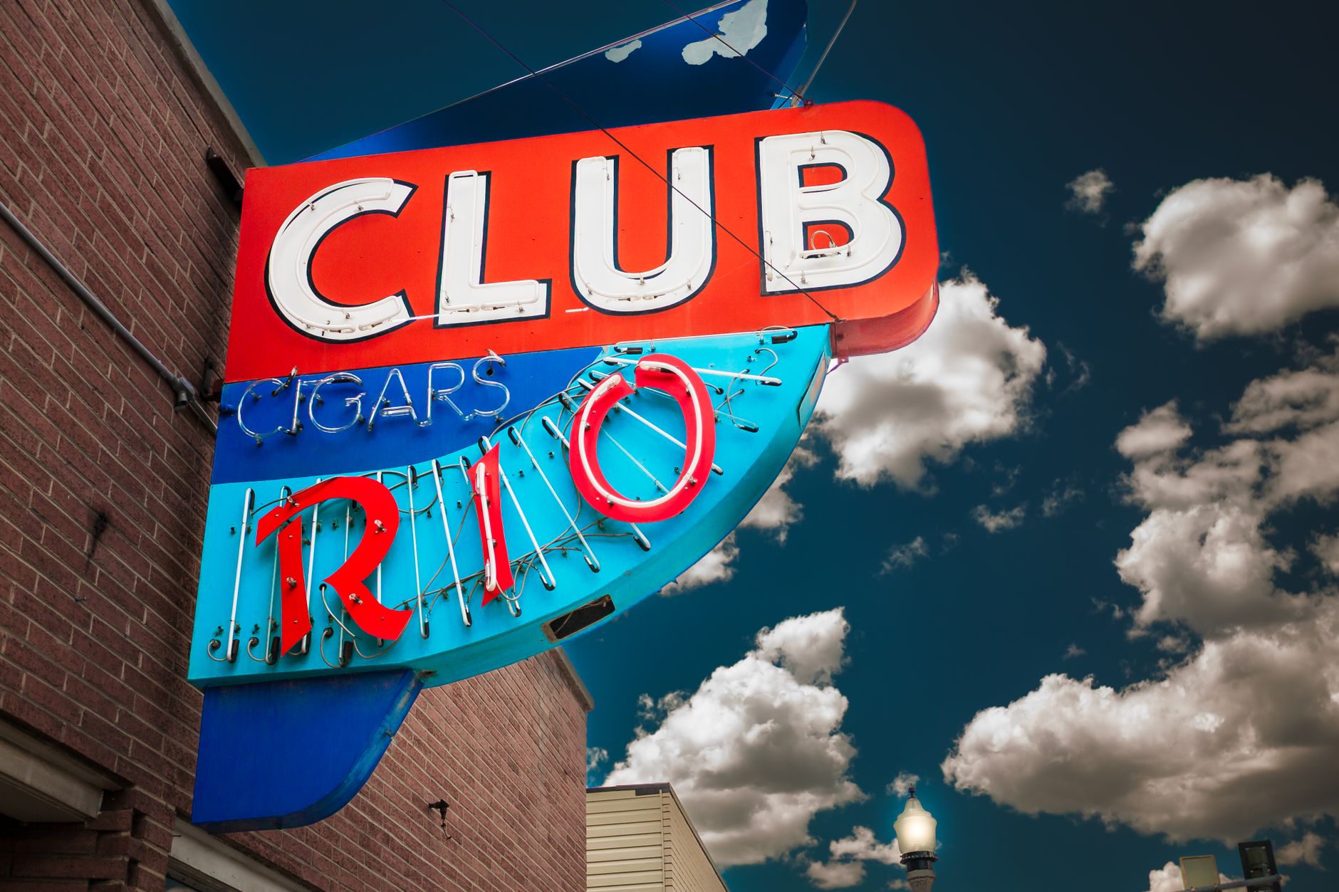 Vintage neon sign for the El Rio night club in Elko, Nevada against a cloudy sky.