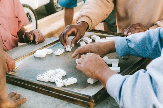 People playing dominoes on a street side table in São Paulo, capturing everyday life.