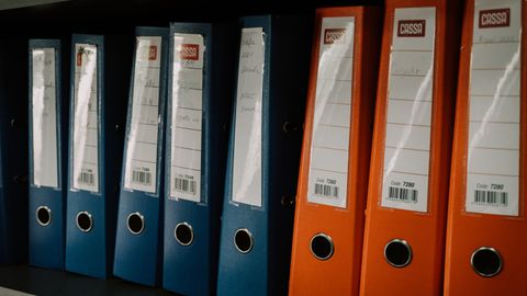 Row of colorful office binders neatly arranged on a shelf, ideal for organization concepts.