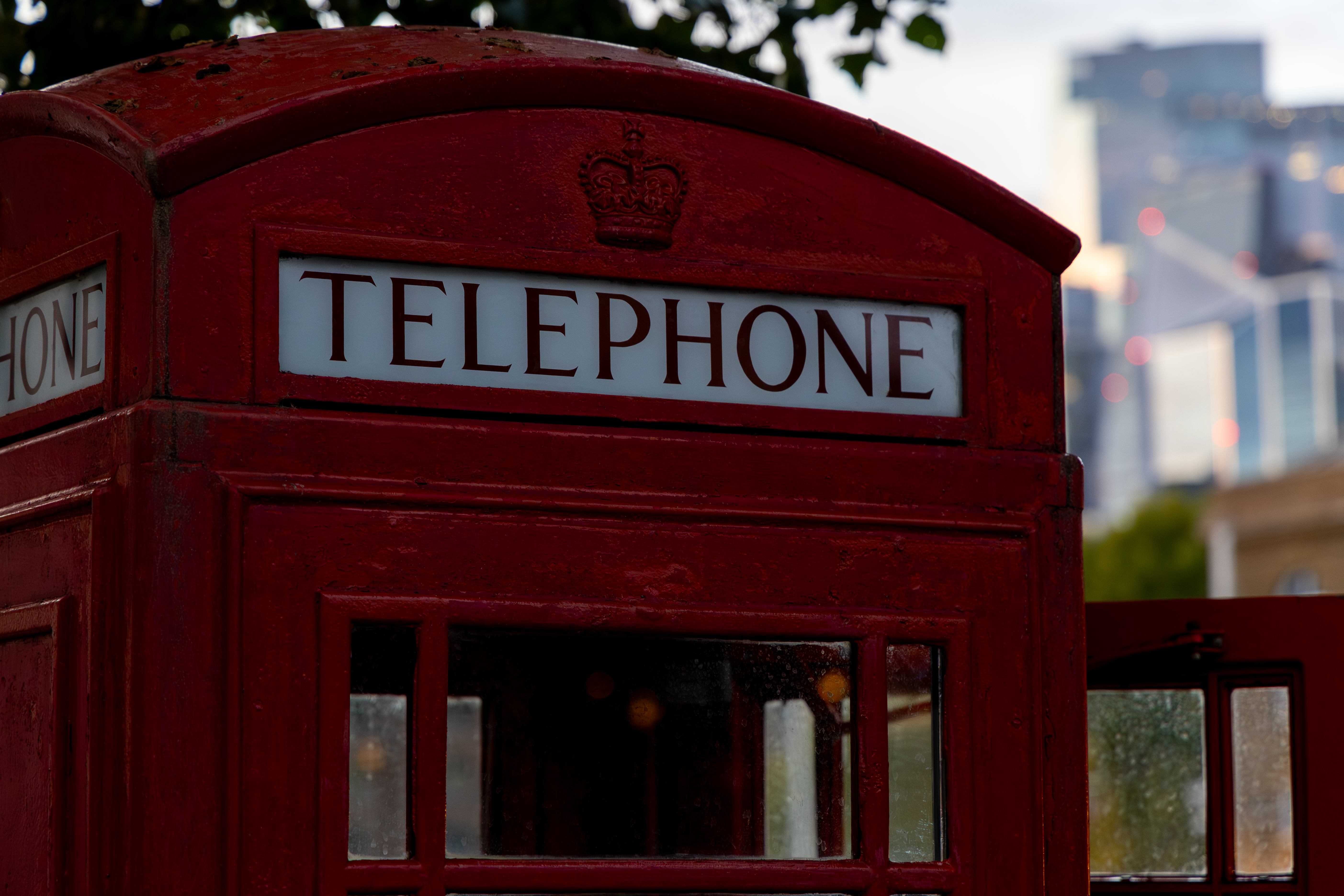 Classic red telephone booth set against a modern London skyline, showcasing British heritage.