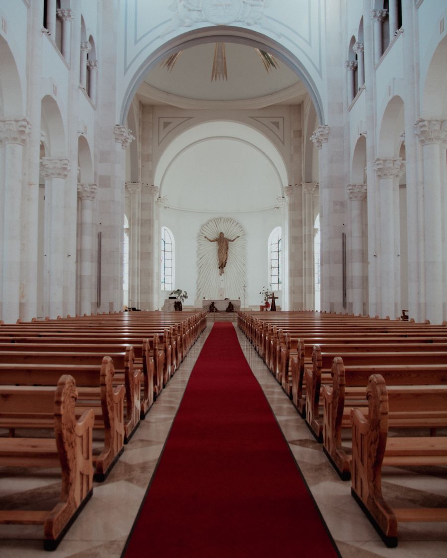 Interior de iglesia católica con bancos y altar