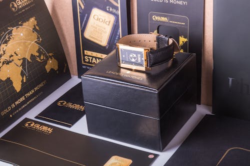 Rectangular Gold-colored Watch With Black Strap on Black Box