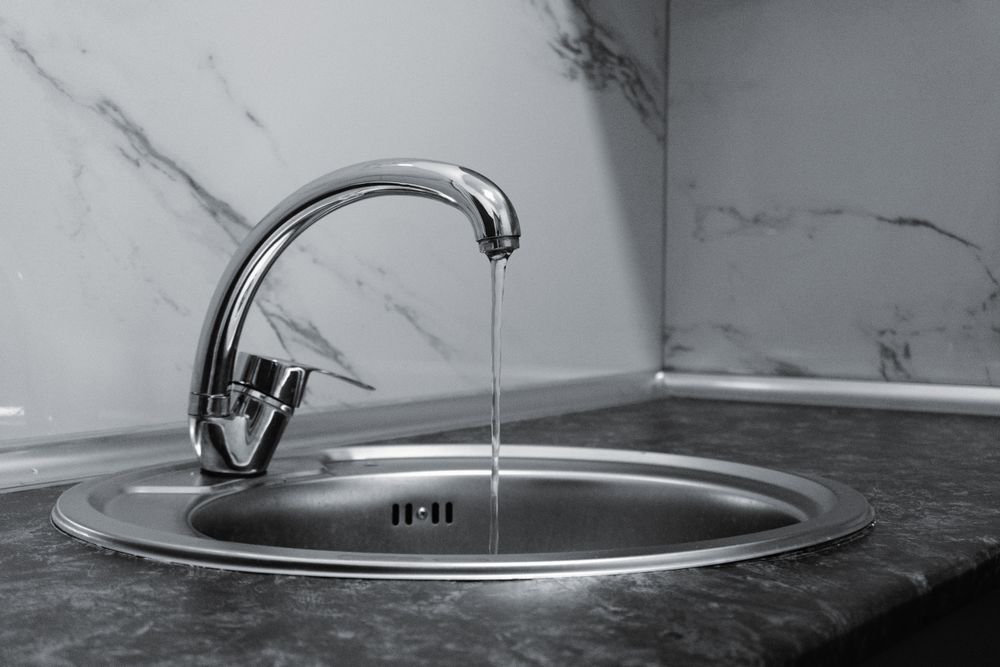 Modern chrome kitchen faucet with water running