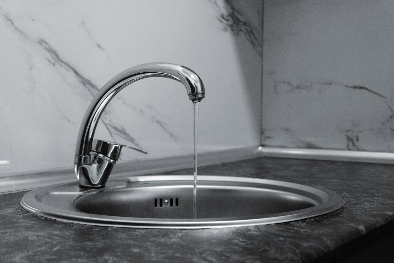 Modern chrome kitchen faucet with running water