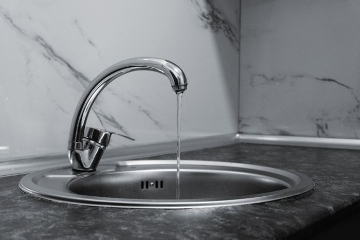 Chrome kitchen faucet with running water