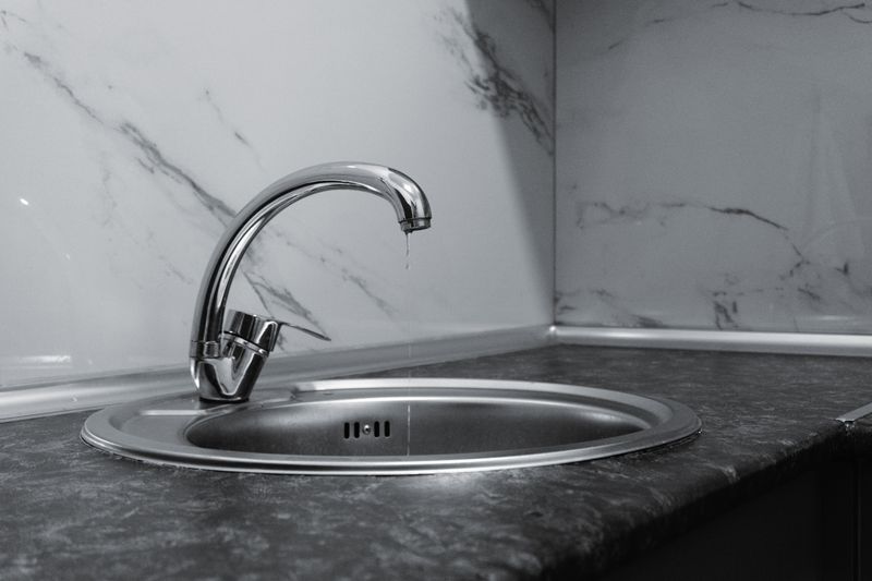 A clean and modern kitchen sink with a chrome faucet, highlighting minimalist design and water conservation.