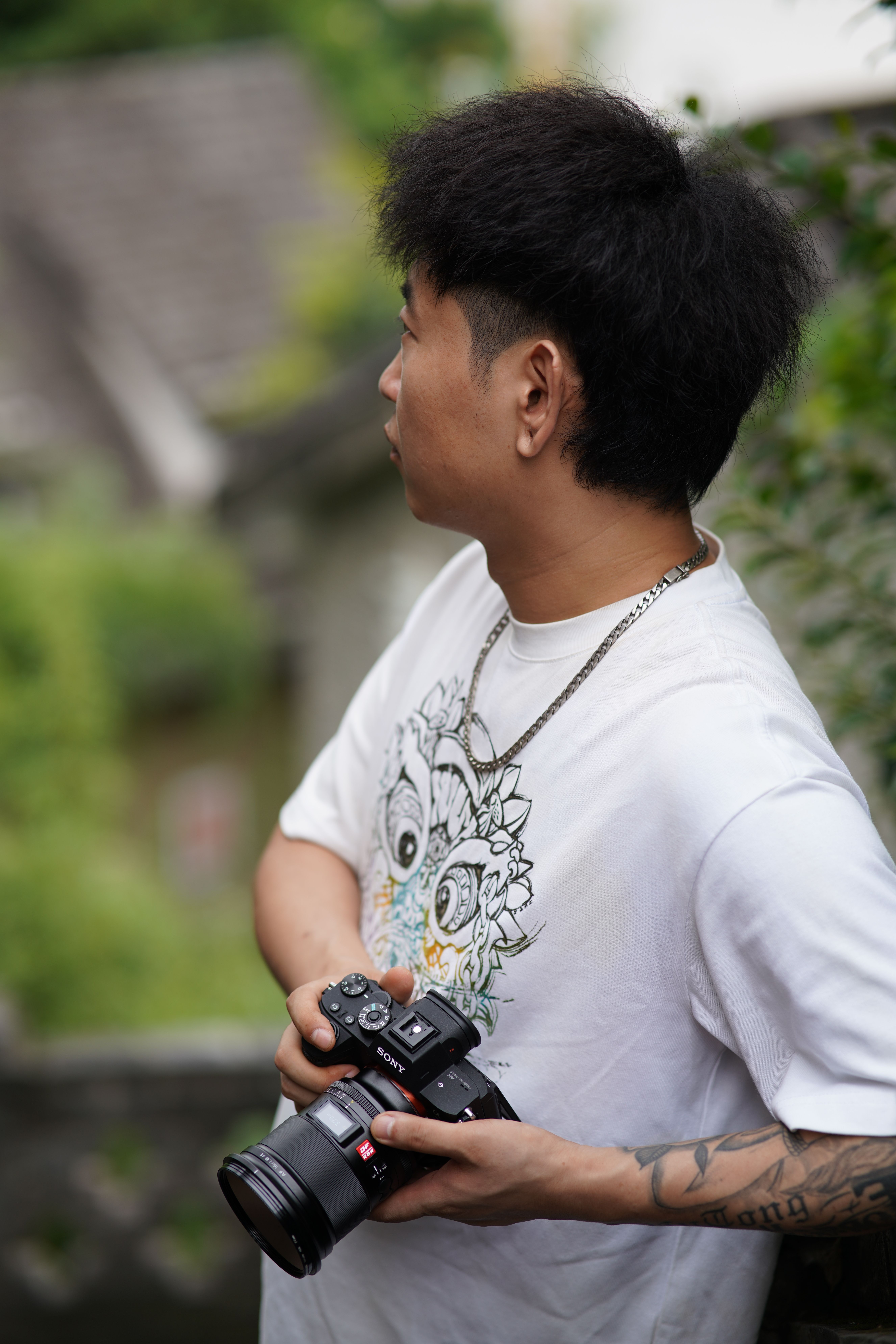 A young photographer holding a camera while exploring an outdoor setting, showcasing creativity and focus.