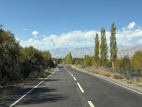 Free A picturesque road in a mountainous landscape with fall foliage and clear blue skies. Stock Photo