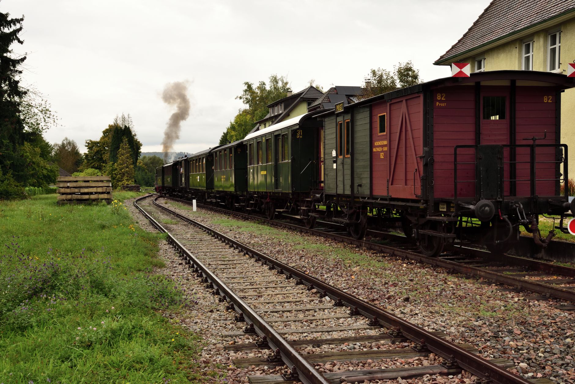 A vintage steam train travels through Kandern, Germany, showcasing historic railway charm in an autumn setting. — free online jigsaw puzzle on JigsawPuzzlesFreeOnline.org