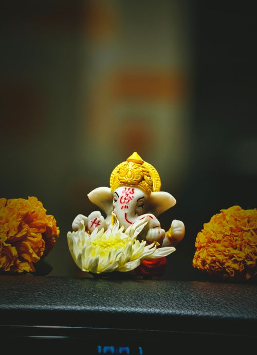 Free A beautiful depiction of a Lord Ganesha idol adorned with marigold flowers. Stock Photo