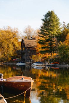 Idyllic lakeside cottage surrounded by vibrant fall foliage in North Hatley, Québec.