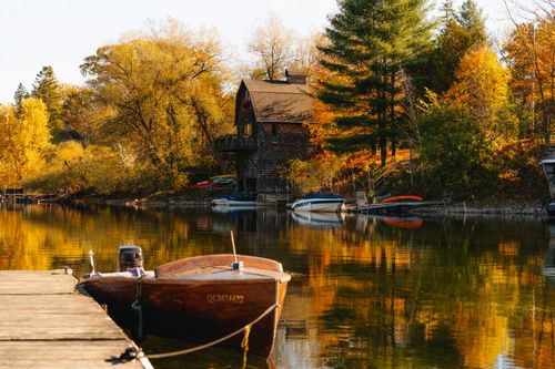 Free Picturesque autumn scene with a house and boats on a lake in North Hatley, Québec. Stock Photo