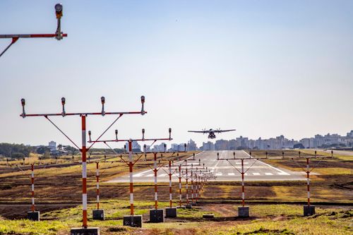 Free An airplane lands on the runway at Londrina Airport, Brazil, with cityscape in background. Stock Photo