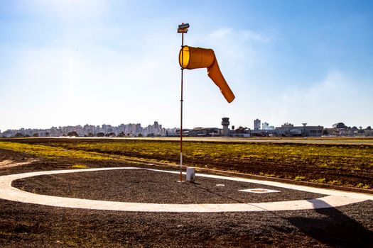 View of a windsock and control tower at Londrina airport highlighting aviation and communication.