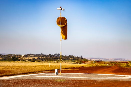 Wind sock on rural airfield in Londrina, Brazil, under clear blue sky.