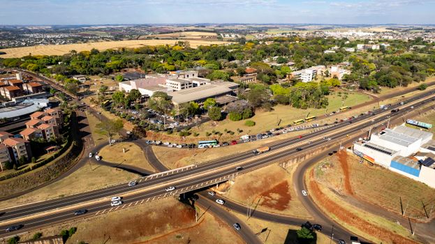 Aerial shot of Londrina, Paraná, Brazil, depicting suburban areas, highways, and lush greenery.