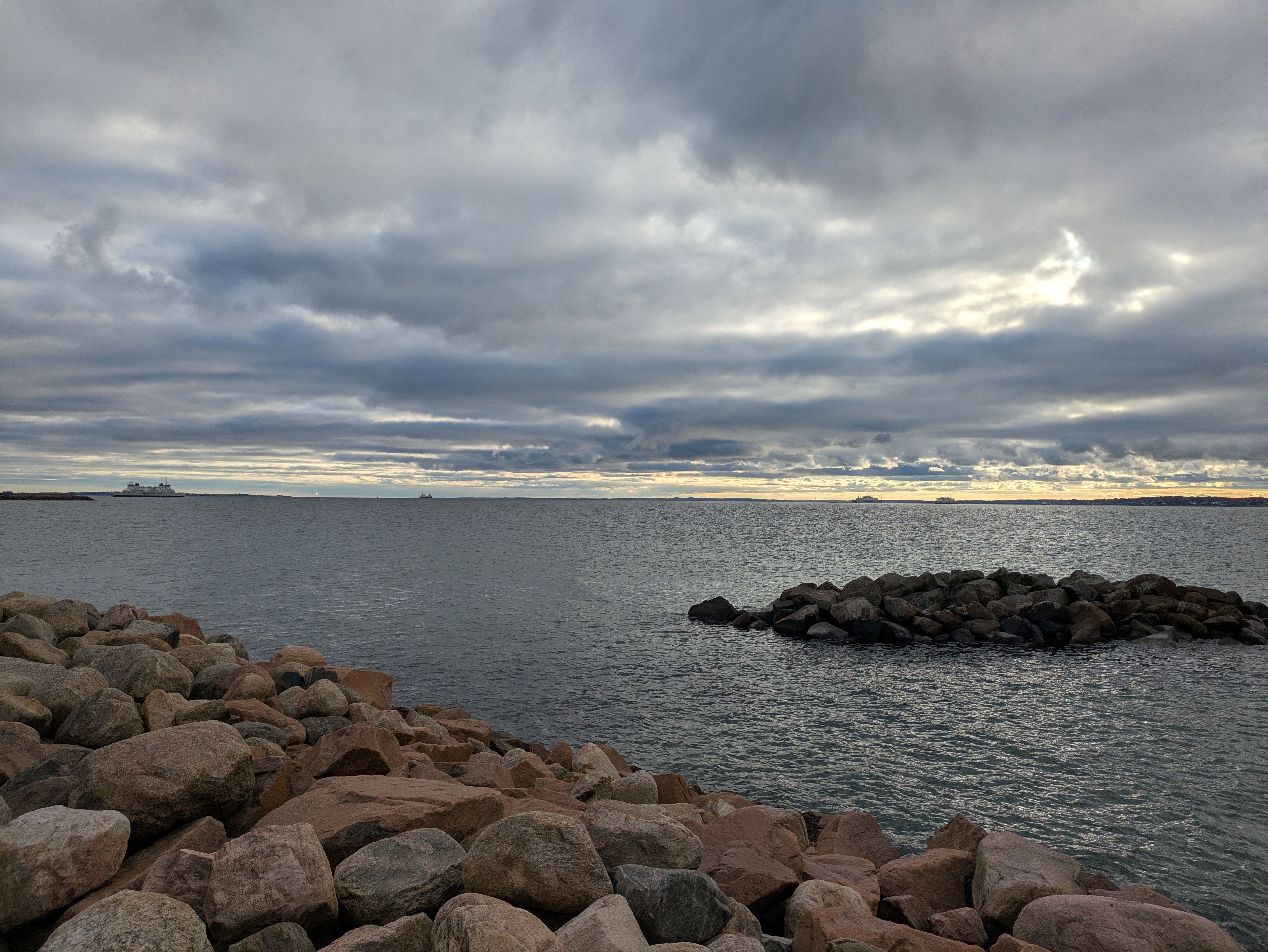A ferry approaching Heltermaa harbour on Hiiumaa under a wide grey Baltic sky