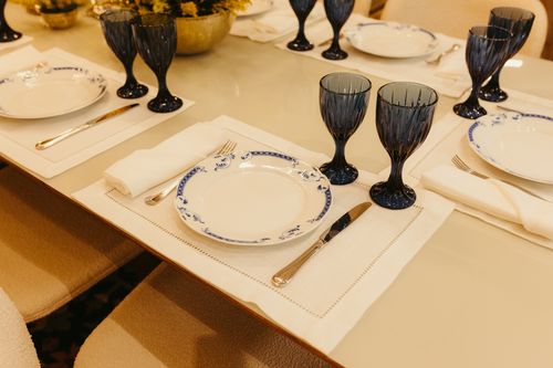 Free Stylish dining table setup with blue goblets, white plates, and cutlery. Stock Photo