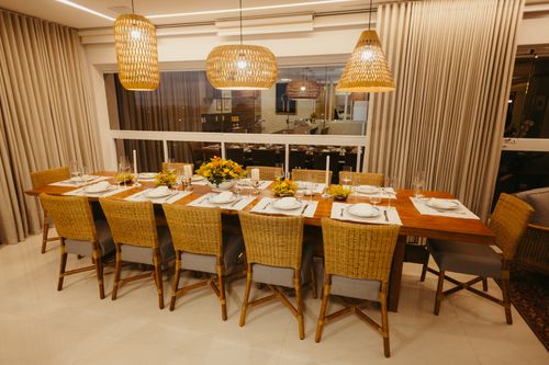 Free A beautifully arranged dining table with rattan chairs and floral centerpiece in a modern setting. Stock Photo