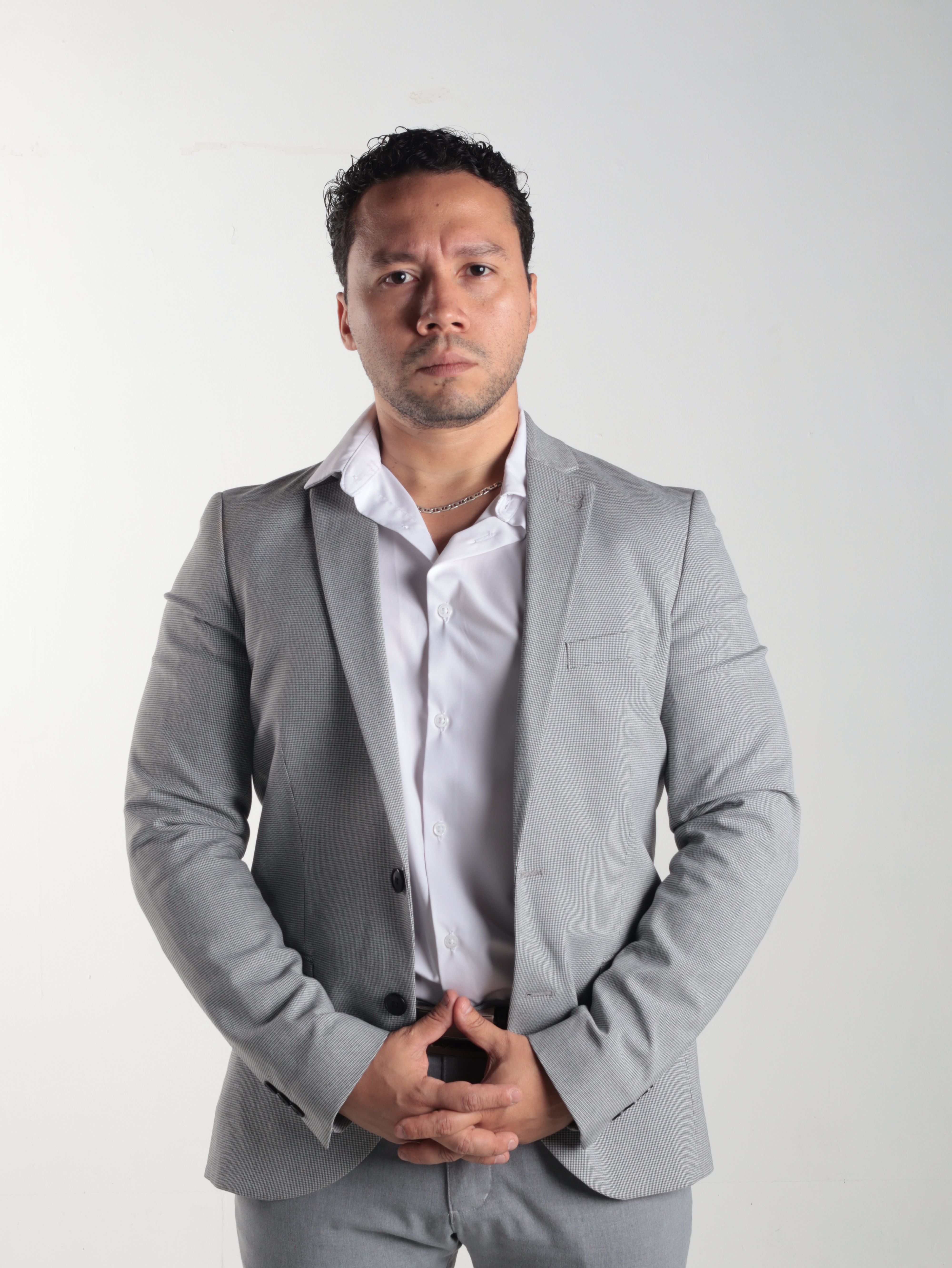 Confident man in business attire posing against a white background, embodying professionalism.