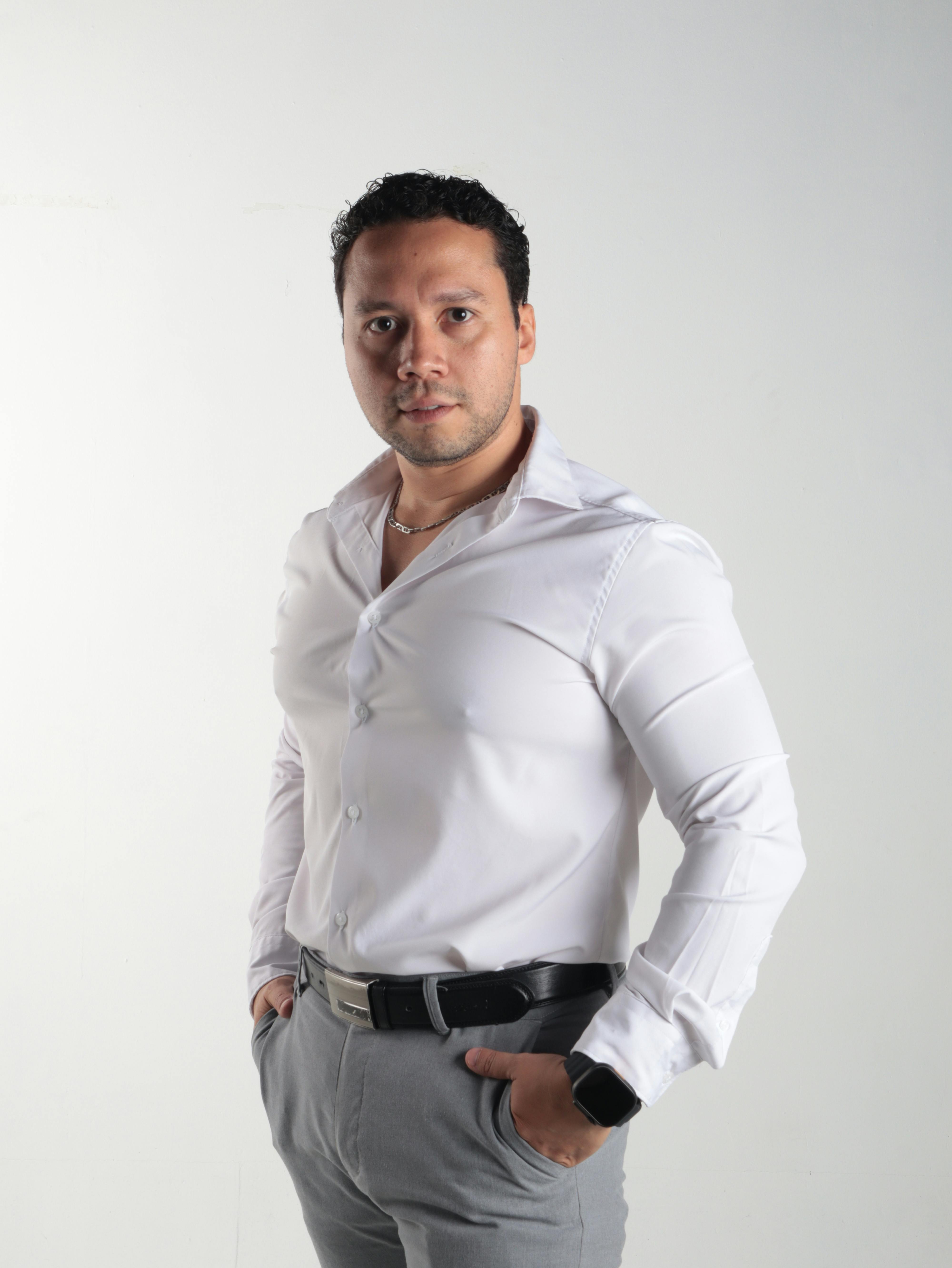 Portrait of a confident man in a white shirt and gray pants indoors, perfect for business or lifestyle themes.