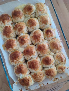 Golden brown cheesy garlic rolls freshly baked in a tray, perfect for a delicious meal.