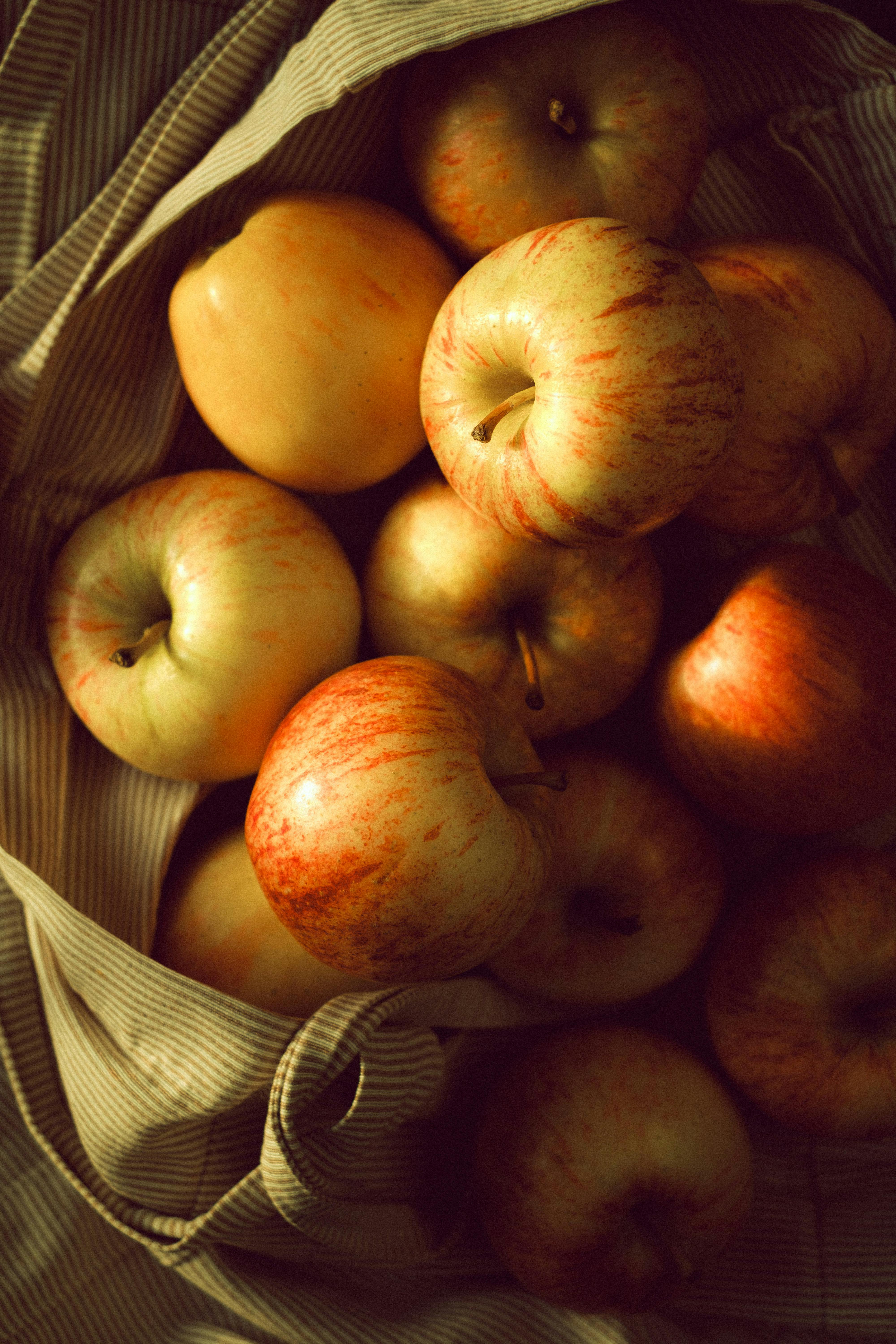 Gratis En samling friske røde epler i en rustikk tøypose, som viser frem deres livlige og naturlige appell. Arkivbilde