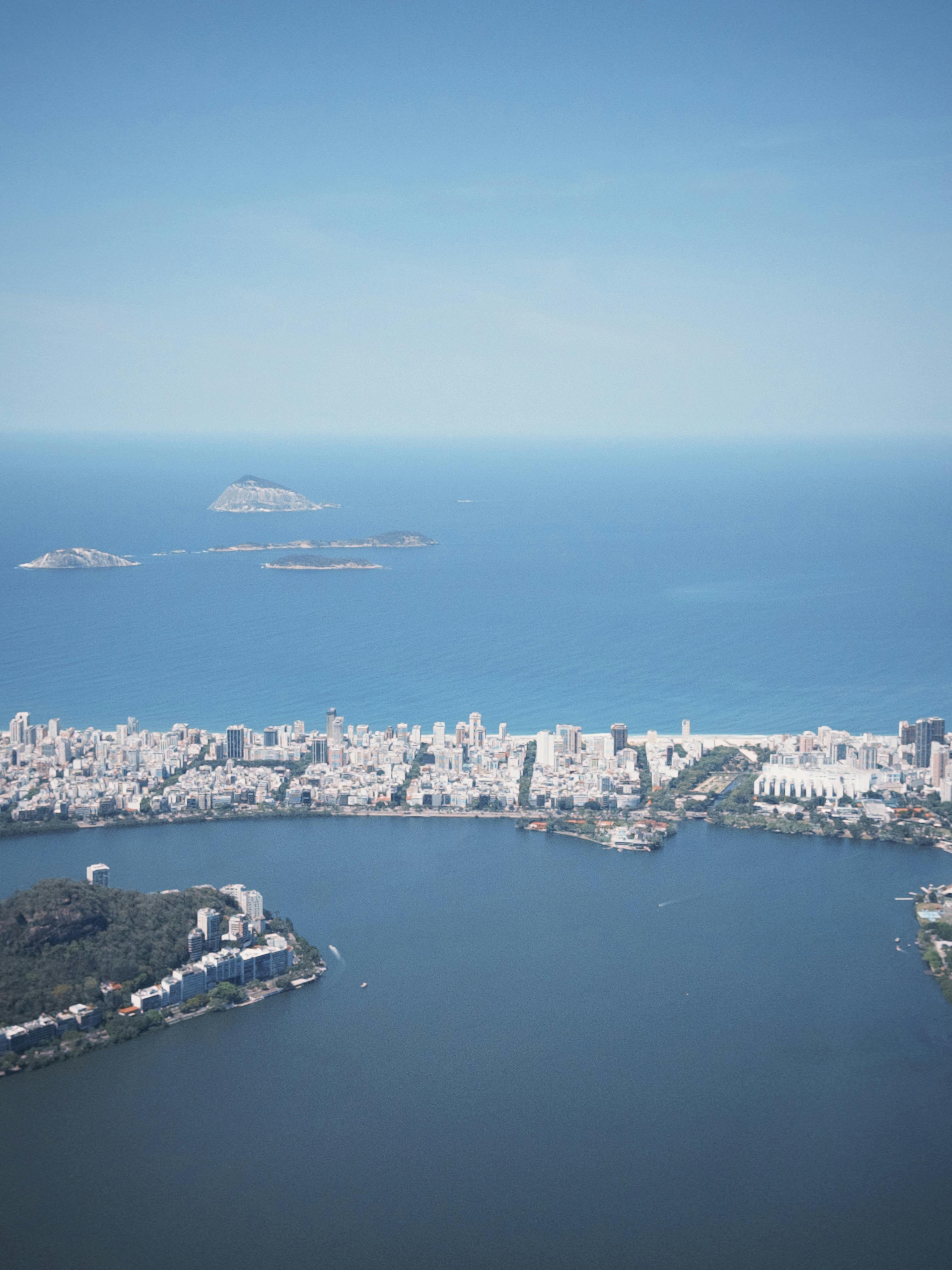 A stunning aerial view of Rio de Janeiro showcasing the coastline and cityscape under clear blue skies.