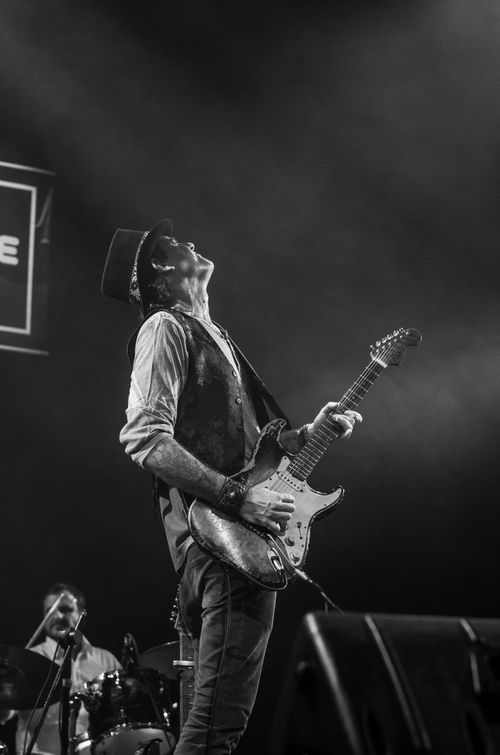 Free Energetic guitarist on stage during a live rock concert, captured in black and white. Stock Photo