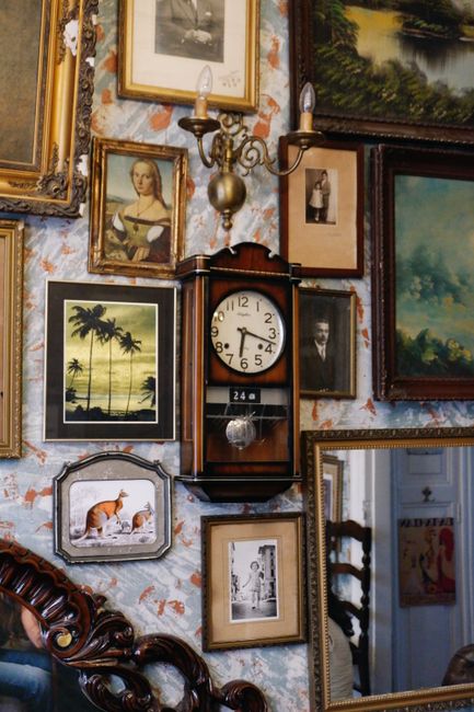A collection of vintage art and an antique clock creates a nostalgic ambiance.