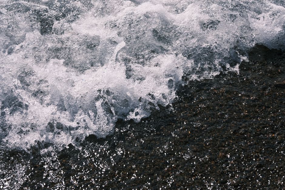 Close-up of a powerful ocean wave crashing on a rocky shore, capturing the beauty and energy of nature.
