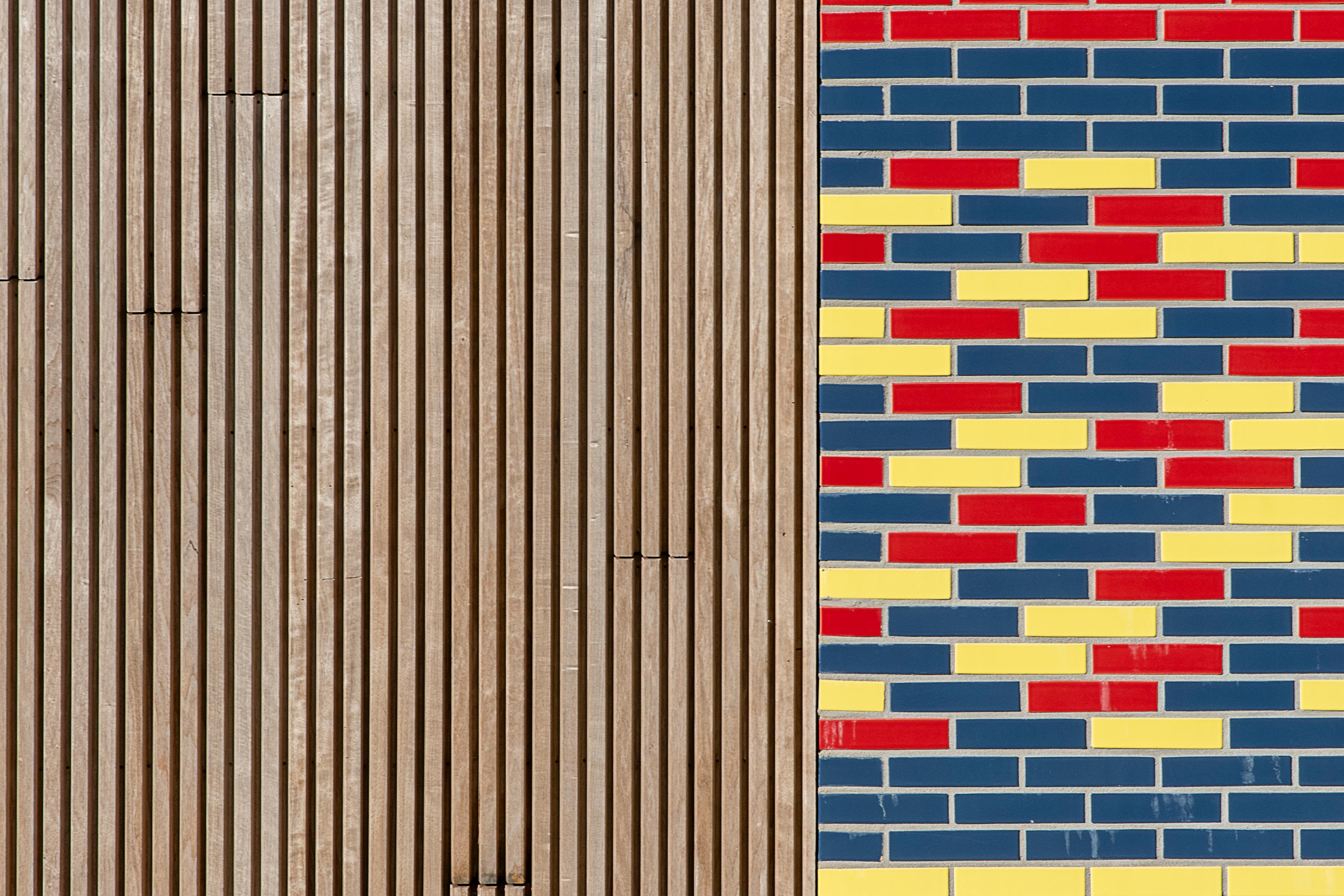 Kostnadsfria Närbild av färgglada tegel- och träpaneler som visar upp modern arkitektonisk design. Stock foto