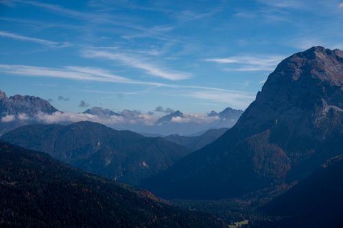 Free A stunning view of a mountain range under a vibrant blue sky with scattered clouds. Stock Photo