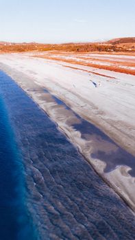A stunning aerial view of Salda Lake with clear blue water and sandy shoreline, captured at golden hour.