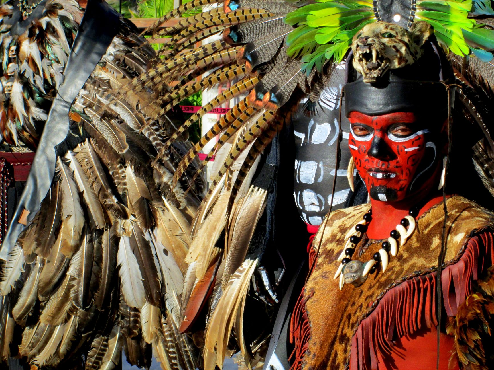 Mayan warrior in vibrant costume with feather headdress and face paint, Cancun.