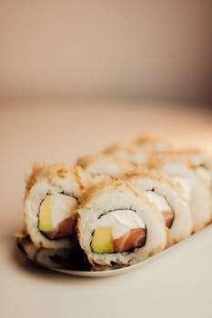 Delicious sushi rolls with salmon, avocado, and cream cheese on a plate.