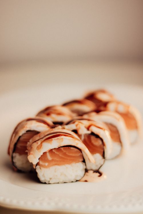 Free Close-up of a salmon sushi roll with sauce, showcasing the cuisine's artistry and flavor. Stock Photo