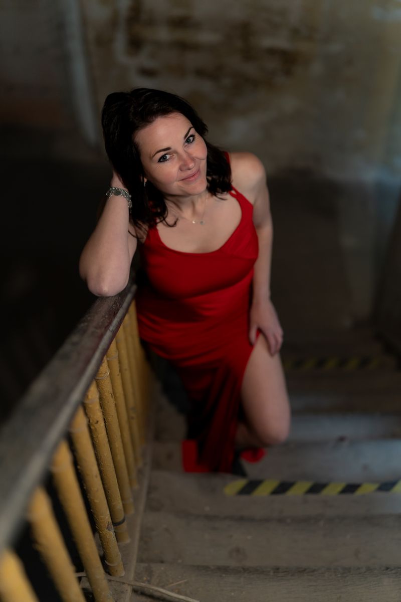 Woman in a red evening gown on a grand staircase