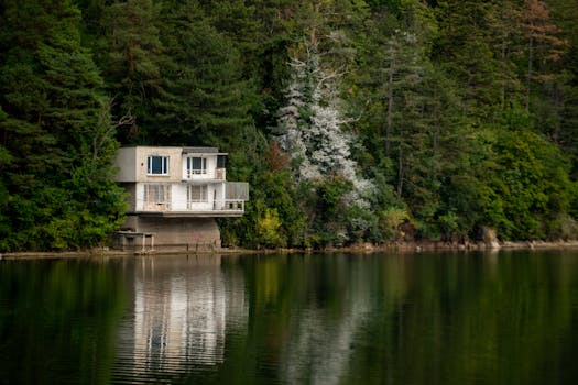 Modern lakeside house nestled in the lush forest of Sofya, Bulgaria, reflecting peacefully on the water.