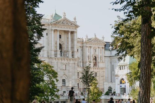 Free Capture of the Hofburg Palace in Vienna showcases stunning Baroque architecture amidst lush greenery. Stock Photo
