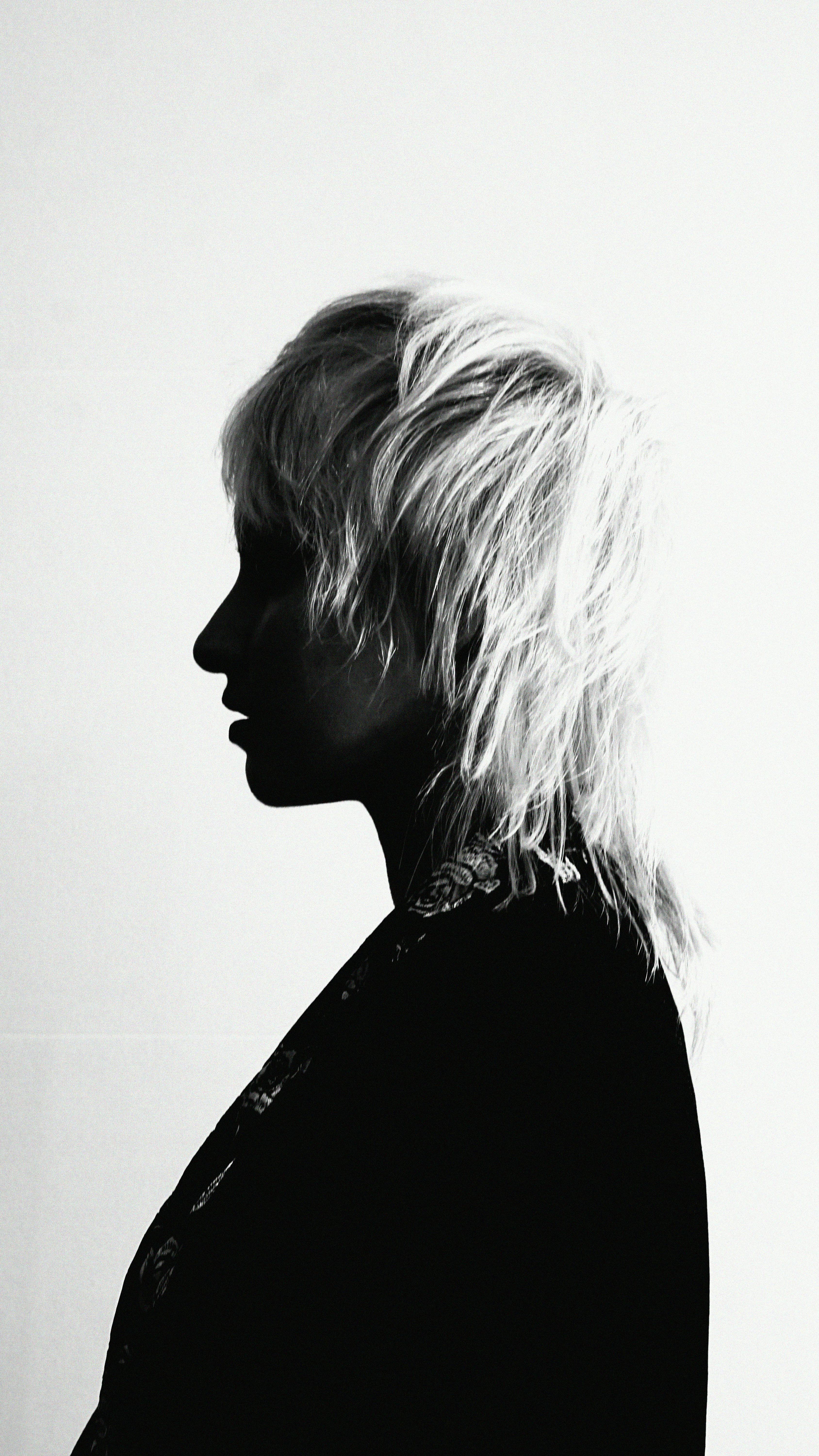 A striking black and white silhouette of a person with bold hairstyle.