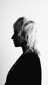 A striking black and white silhouette of a person with bold hairstyle.